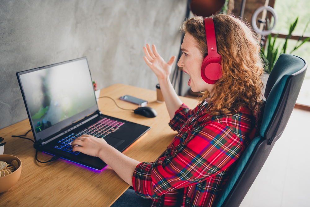 frustrated,woman,with,headphones,using,laptop,at,home,office